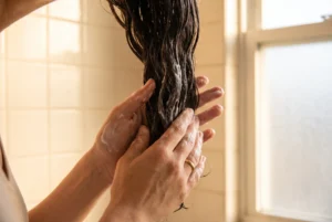 Applying a rich protein-positioned mask to damp mid-lengths of dark hair