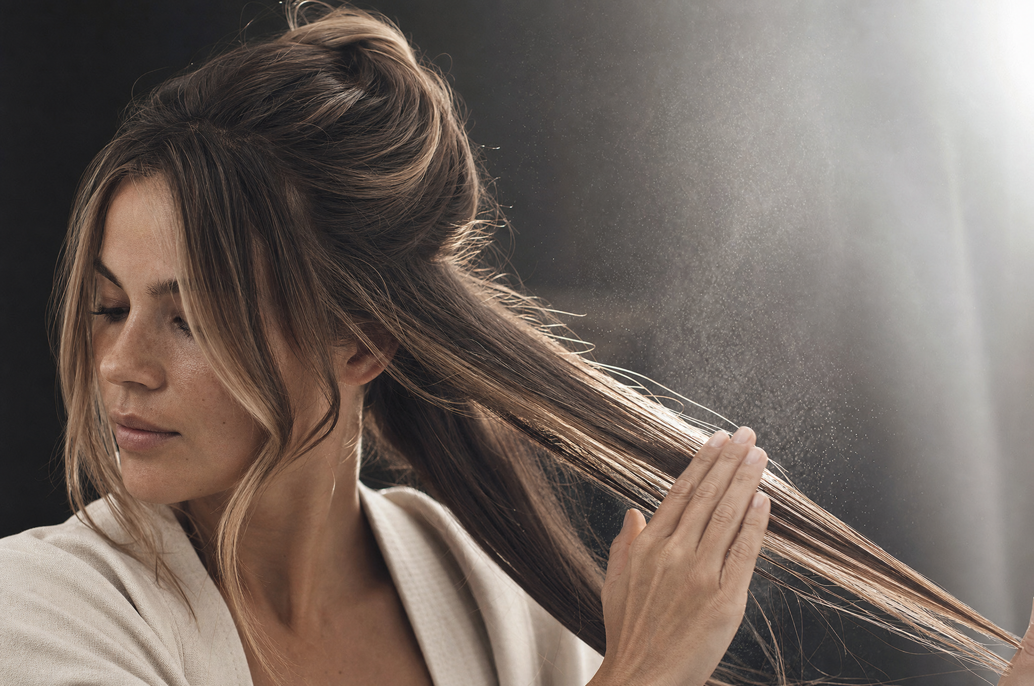 Applying heat-protection mist to sectioned colour-treated hair