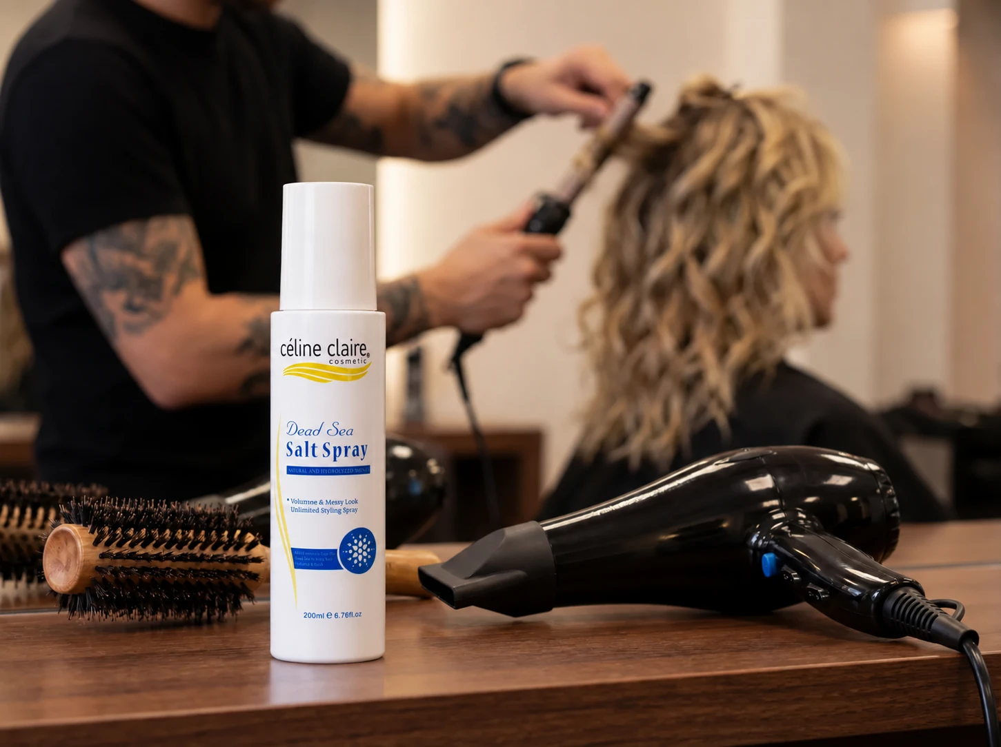 Dead Sea Salt Spray on a salon station beside hair being blow-dried into loose textured movement.
