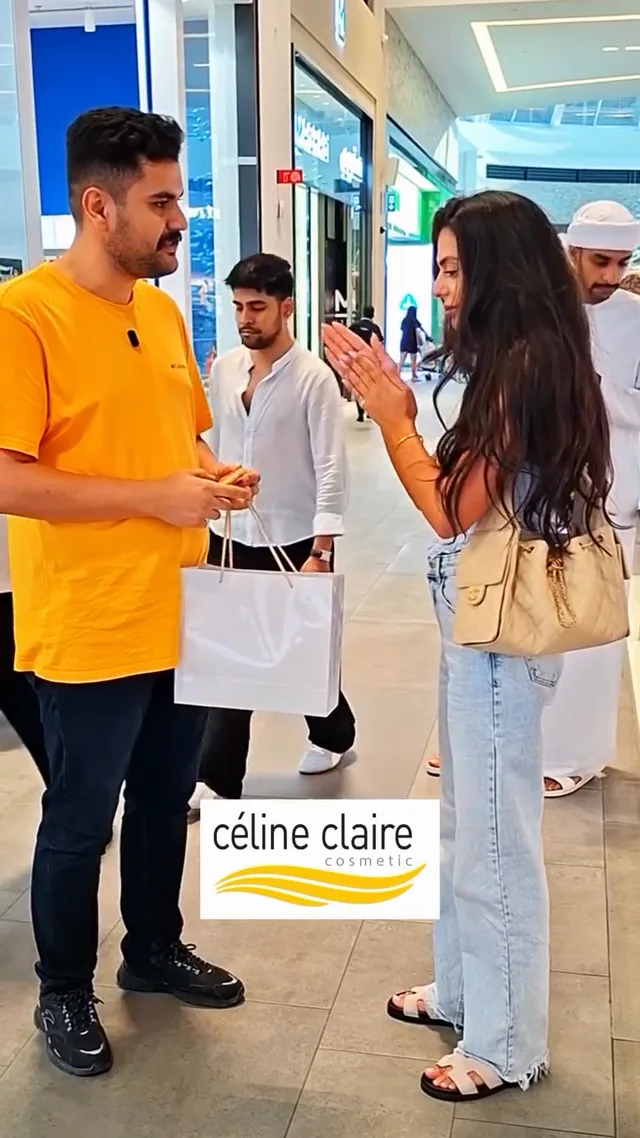 A shopper trying Moroccan Argan Oil at a Celine Claire stand in a shopping mall