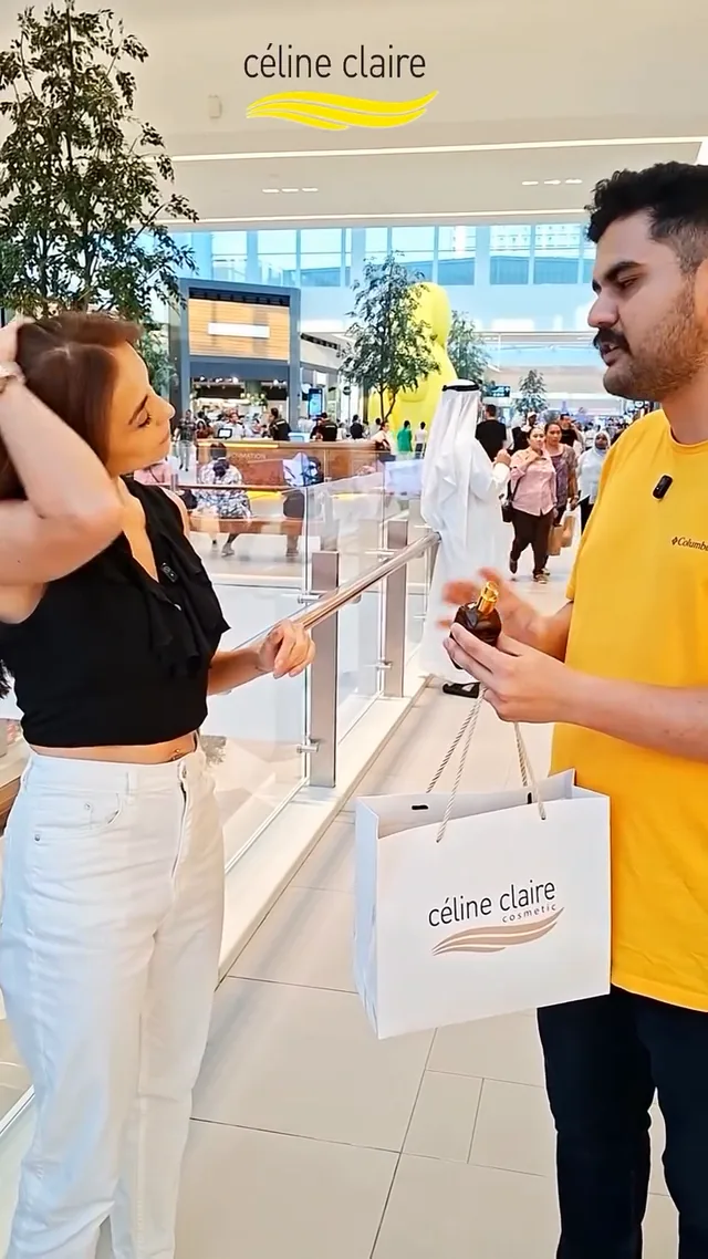 A shopper talking to a Celine Claire team member while holding Moroccan Argan Oil