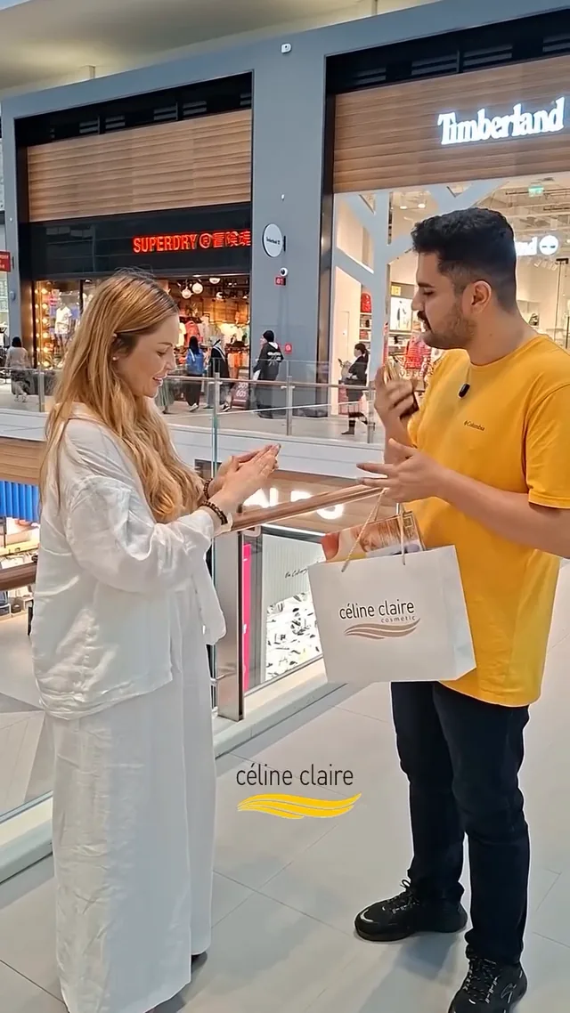 A shopper being handed Moroccan Argan Oil at a Celine Claire mall stand
