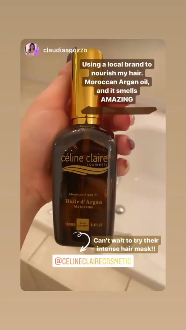 A hand holding the Celine Claire Moroccan Argan Oil bottle up to the light